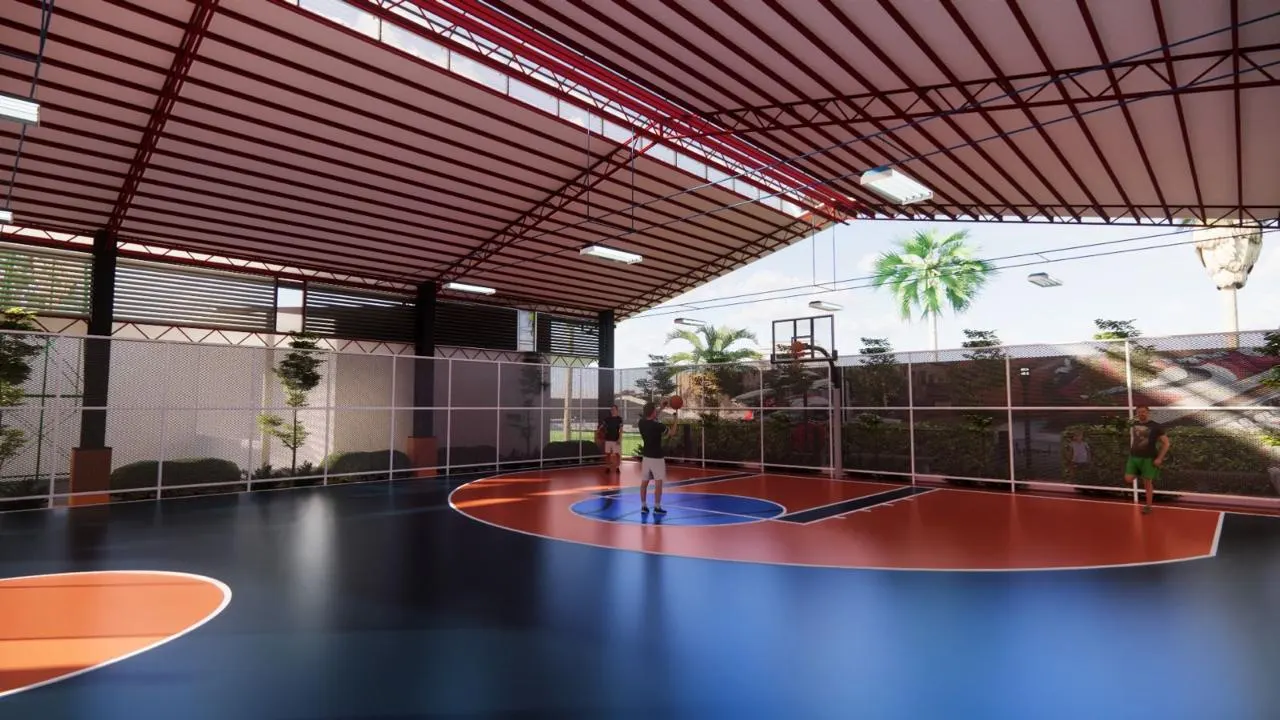 Covered sports court under a red steel roof with netted sides and planting (1)