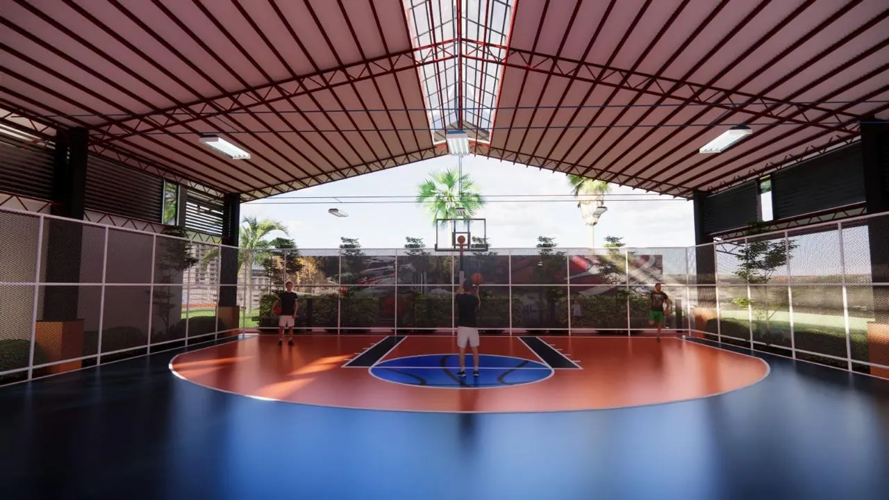 Covered sports court under a red steel roof with netted sides and planting (2)