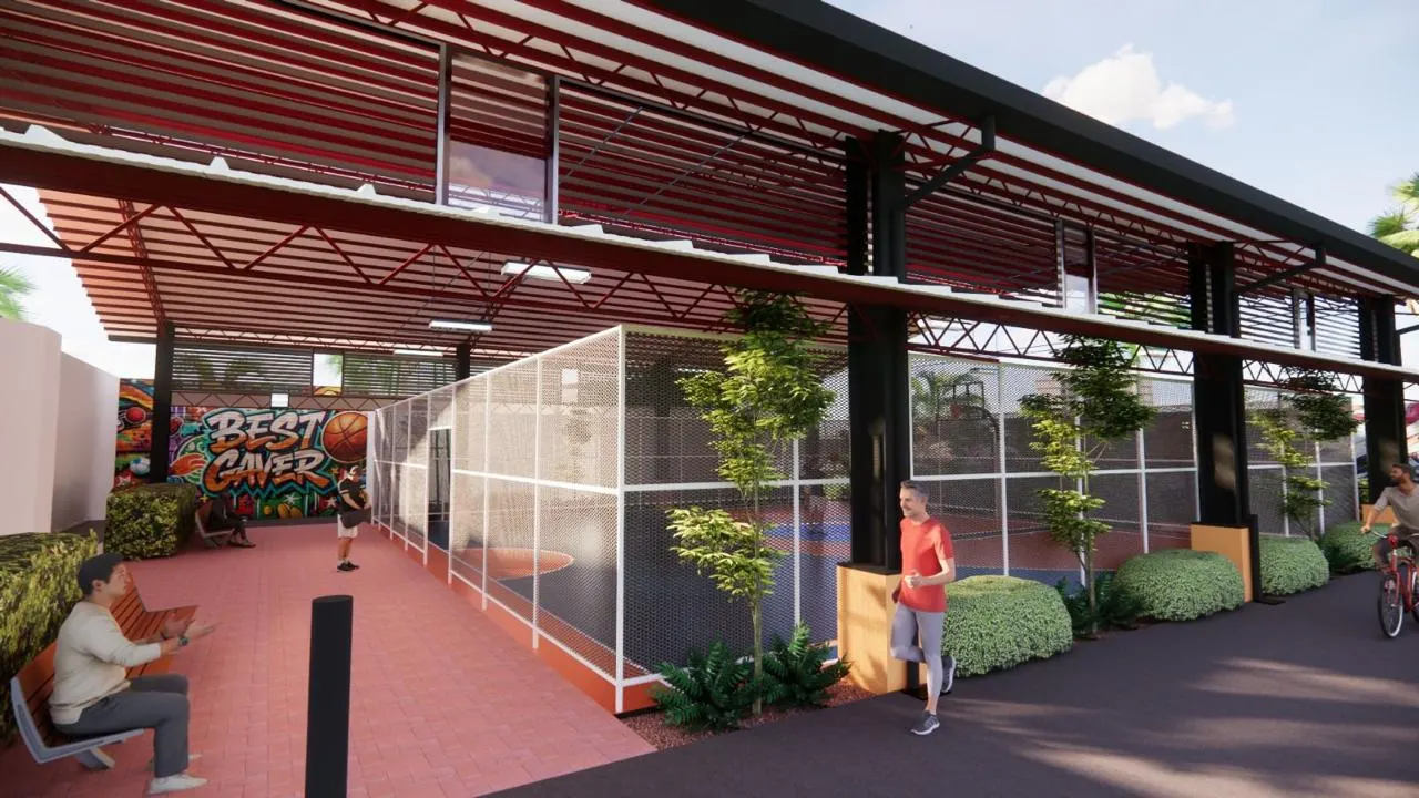 Covered sports court under a red steel roof with netted sides and planting (5)