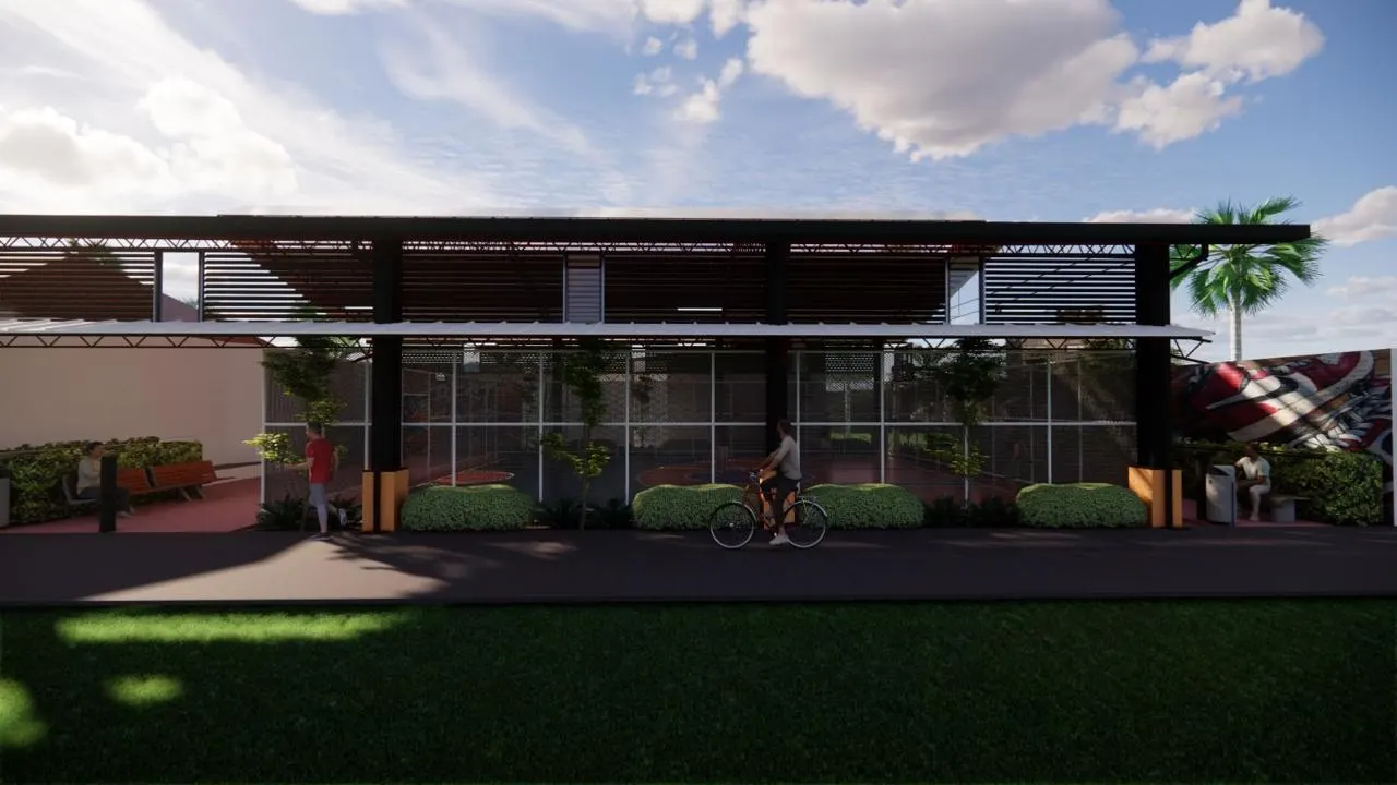 Covered sports court under a red steel roof with netted sides and planting (6)
